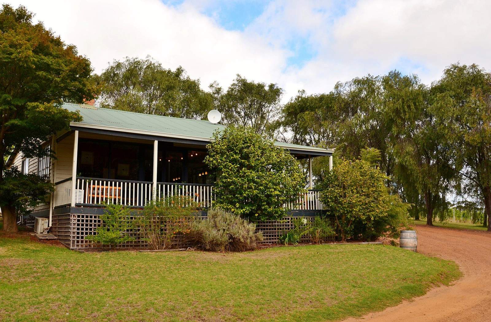 A low country guesthouse behind a wide lawn and established trees
